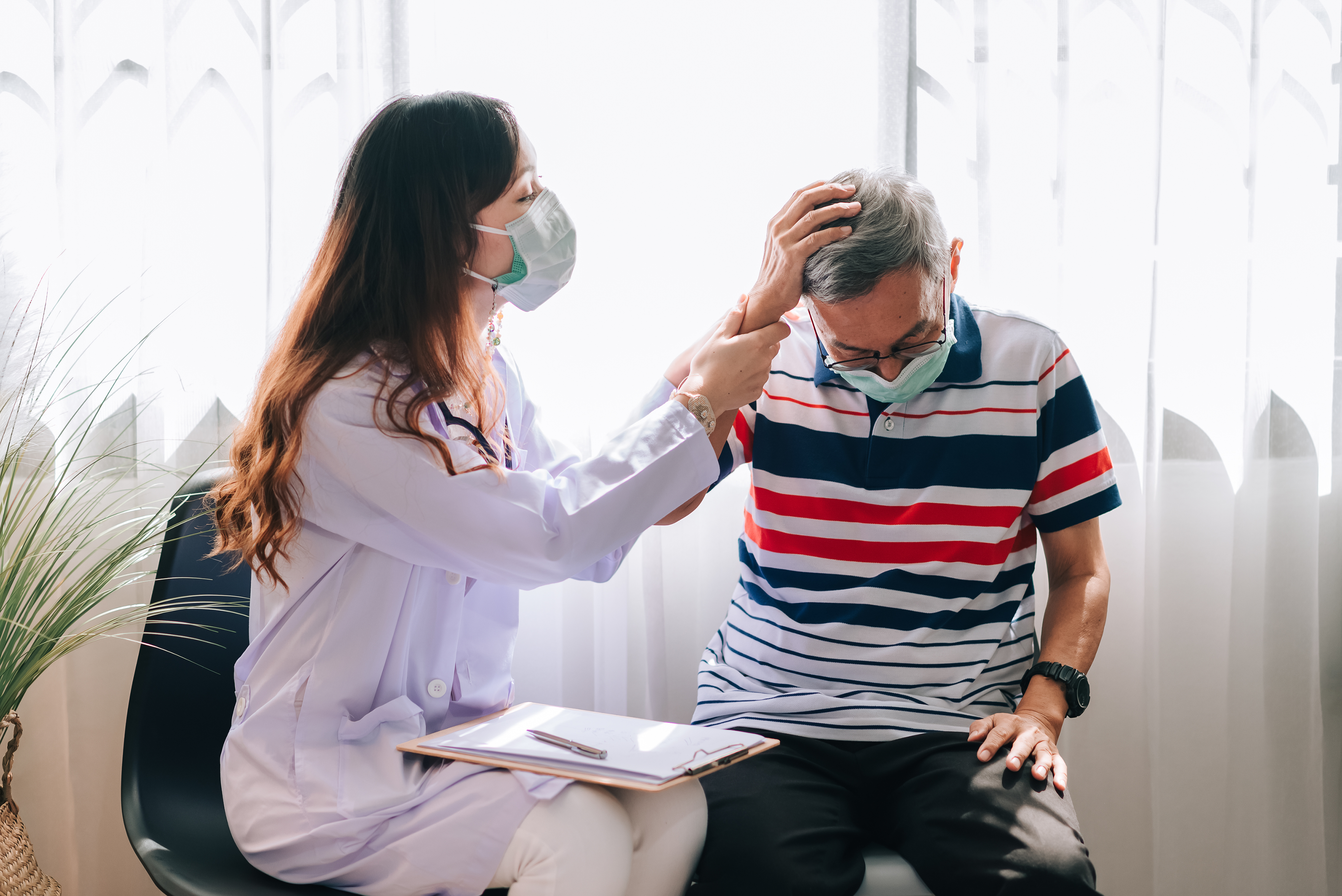 Dokter memeriksa pasien yang mengeluh sakit kepala