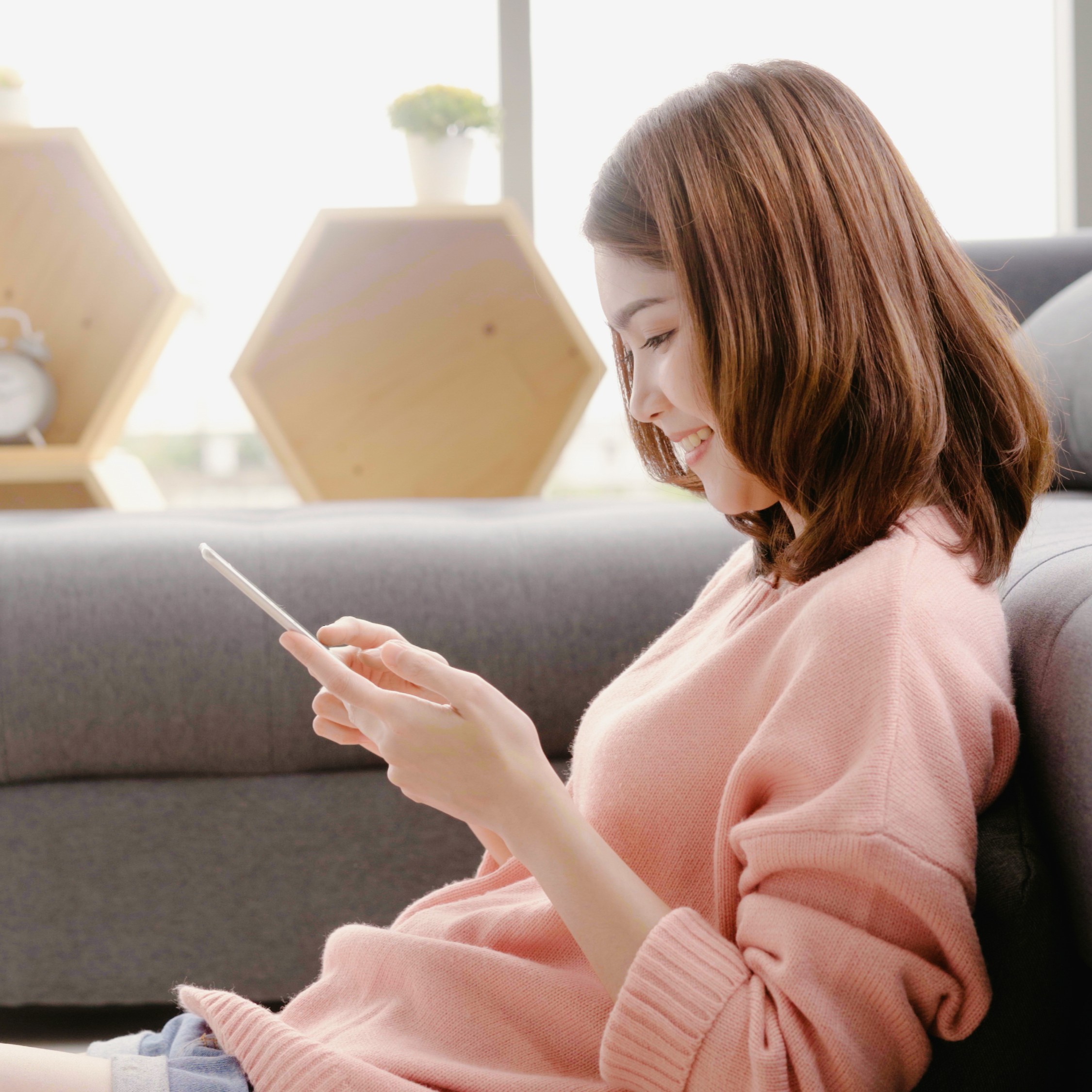 chinese woman using phone on sofa