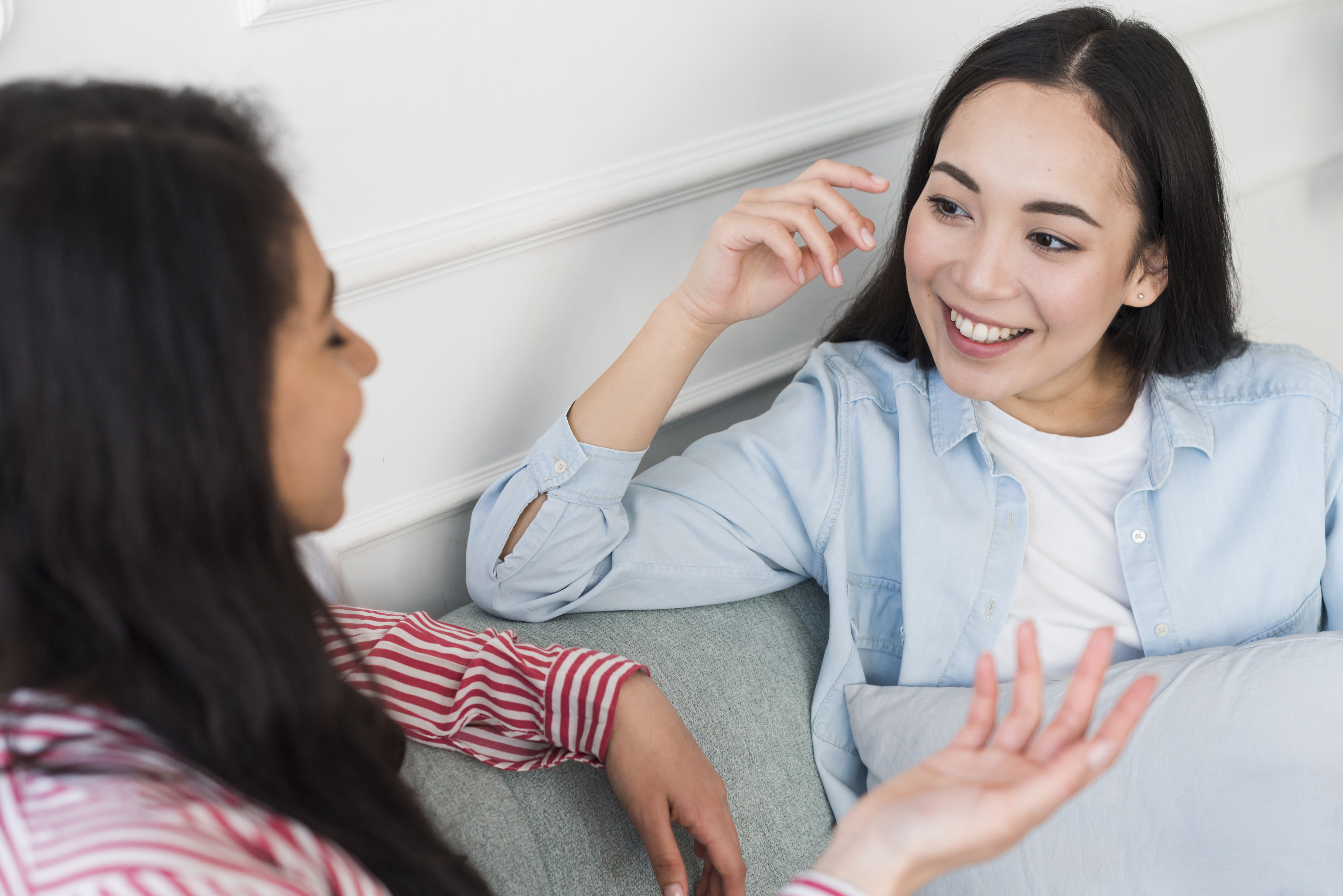 Multi ethnic women chatting on sofa